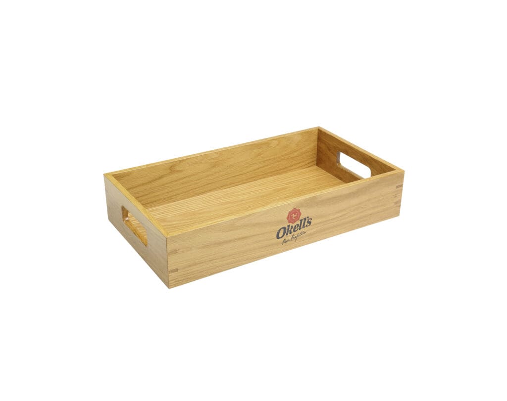 Okell’s branded wooden serving tray with cut-out handles, natural wood finish and printed logo on the front panel.