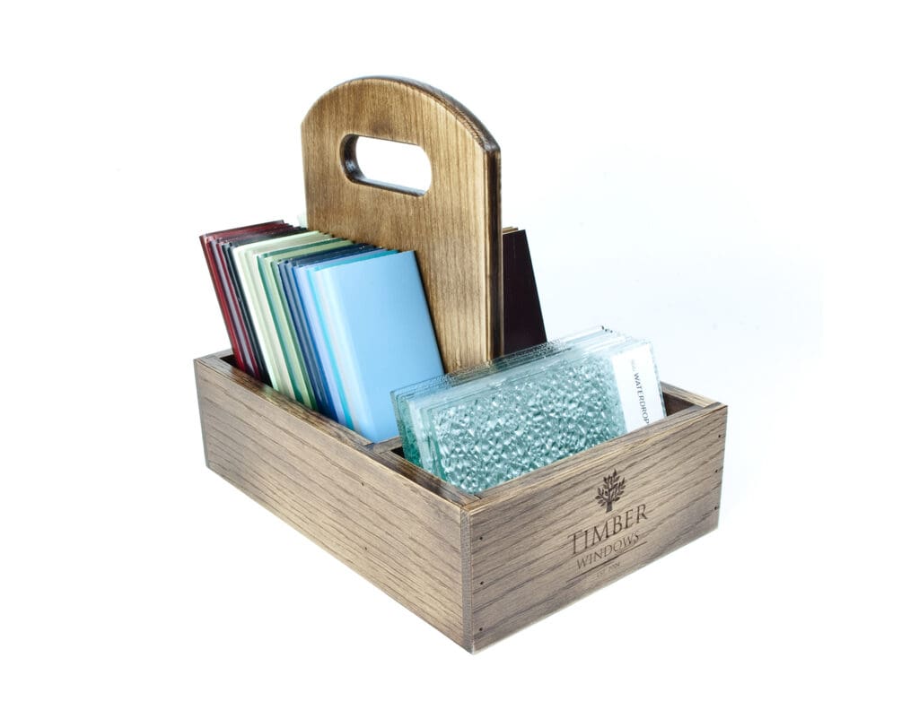 Wooden POS sample caddy with carry handle holding glass and material samples, Timber Windows branded.